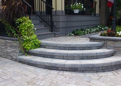 Curved front step with retaining walls design by Rhonda Derue installation by Yards Unlimited Landscaping Inc.