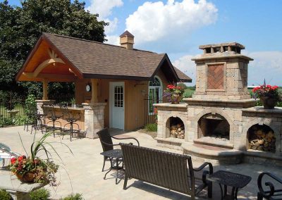 Outdoor fireplace feature and pool cabana design
